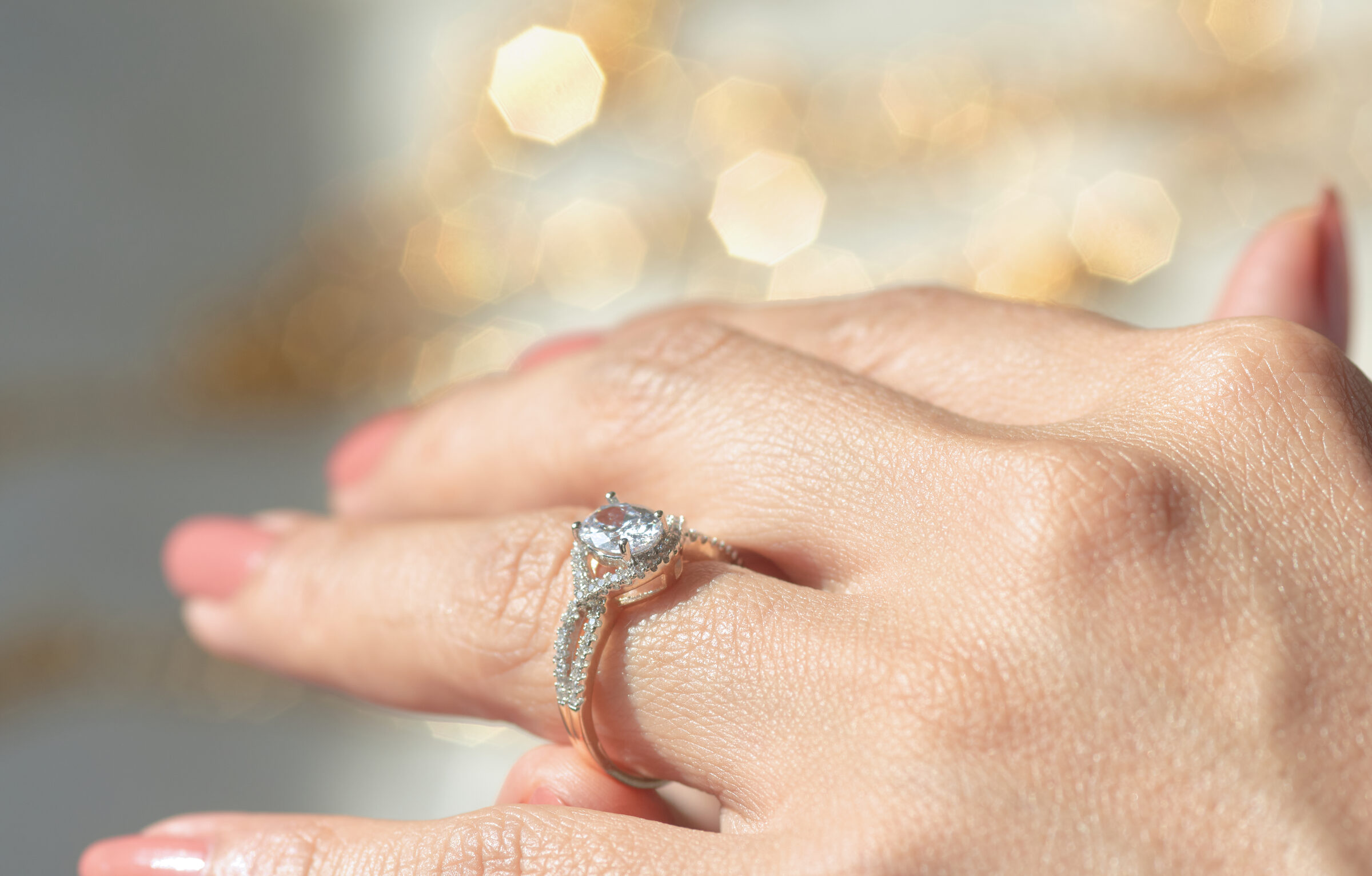 Woman hand wearing an oval diamond ring